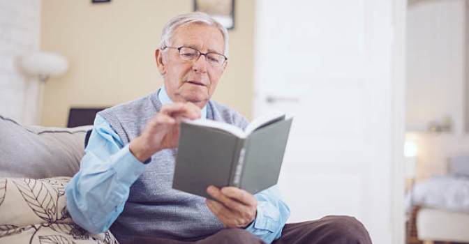 adulto mayor leyendo un libro